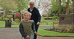 Grandfather chasing young boy in garden, park and outdoor for fun, games and joy. Senior man running after happy kid in nature to play tag
