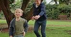 Grandfather chasing young boy in garden, park and outdoor for fun, games and joy. Senior man running after happy kid in nature to play tag