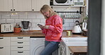 Mature woman, phone and laughing while reading at funny message on social media or mobile app. Happy female model person with a smartphone for communication, chat or connection in a modern kitchen