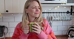 Thinking, morning and a mature woman drinking coffee in a kitchen while happy with a smile. Face of a female model person with a tea cup at home for me time, relax and peace while contemplating life