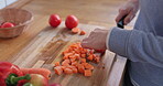 Healthy, food and woman is cut vegetables for nutrition in home for wellness in closeup. Chef, vegan and board with fresh ingredient or carrot in kitchen for lunch for organic meal with hand.