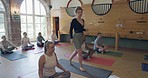 Health, coaching and fitness with teacher in yoga studio for meditation, relax and workout. Wellness, spiritual and exercise with group of people in class for pilates, mindfulness or holistic healing