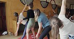 Pilates, teacher and group doing exercise in a zen studio for mind, body and chakra balance. Calm, meditation and people stretching for wellness, health and self care workout in a community gym class