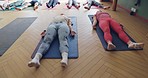 Yoga, balance and people laying for breathing with body, mind and spiritual exercise. Wellness, health and meditation mindset with calm, peace and zen students in a pilates class in a workout studio.