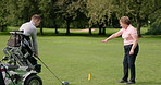 Sports, golf and man in wheelchair on course for playing game, training and competition for recreation. Fitness, golfer and person with disability with golfing club, ball and instructor for fun hobby
