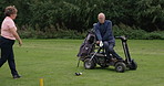Senior man, golf cart and hitting ball on grass, lawn or green field of person with a disability in sports. Mature male person with assistant in golfing, support or help for swinging stick or club