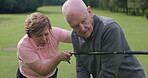 Golf course, instructor teaching man and club at field, nature or outdoor for help in lesson. Golfers, coach and senior person learning sports, healthy exercise and conversation, training or summer