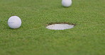 Closeup, golf ball and target for hole on field, course or lawn with shot for winning of game, match and tournament. Sports, challenge and competition for recreation, relaxing and hobby in summer