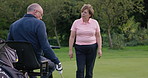 Wheelchair, talking and senior man on golf course for playing game, training or sports for recreation. Retirement, golfer and elderly person with disability and golfing club for fun, hobby and learn