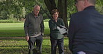 Fitness, talking and a senior friends on a golf course for help or to explain a shot technique to a player. Retirement, hobby or golfing with an elderly man and woman speaking outdoor on a green
