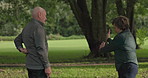 People, golf and talking for strategy on course, field or grass for competition, tournament or game. Mature man, female trainer and advice with consultation for swing, practice and guidance for sport