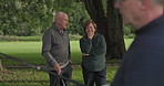 Retirement, talking and elderly friends on a golf course for help or to explain a shot technique to a player. Fitness, hobby or golfing with a senior man and woman speaking outdoor on a green