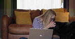 Woman, sitting on floor and laptop with dog, work from home and kiss pet with affection and serious. Freelancer, living room and tech for career, entrepreneur and animals to keep her company for job
