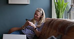 Phone, relax and mature woman networking on social media, mobile app or the internet at home. Smile, technology and female person scroll on cellphone with dog pet on sofa in living room of house.