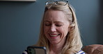 Woman, phone and happy on sofa in living room for text message, notification or internet conversation. Mature person, face or laughing with smartphone on couch in lounge of home for social media meme