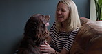 Woman, dog and happy on sofa in living room, relax and talking with care, love or animal in home. Person, pet or labrador with smile, stroke and playful for bonding, loyalty and lounge couch in house
