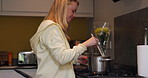 Woman, smile and cooking on stove in kitchen for healthy, delicious and meal for eating. Female person, wife and alone with preparation of dinner with soup for vegan, vegetarian and diet for health