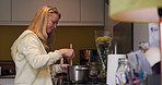 Happy woman, smile and cooking on stove in family home for healthy, delicious or meal. Alone, female person and preparation of dinner, stew or soup in kitchen with spoon, pot and ingredients for diet