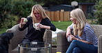 Coffee, friends and playing fetch with a dog in the garden together during a visit in summer for bonding. Pet, ball and mature women laughing in the backyard of a home to relax with conversation