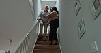 Senior, man or caregiver with walking stick on stairs for guide, helping and support in hospice. Elderly, person or woman with communication, talking and handicap in retirement home for volunteer