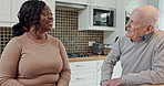 Talking, home and caregiver with senior man for conversation, communication and chat. Retirement, assisted living and black woman with elderly patient for bonding, support and medical care in kitchen