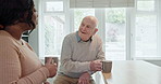 Talking, kitchen and caregiver with old man for coffee, communication and conversation. Retirement home, assisted living and black woman with elderly patient for bonding, support and medical service