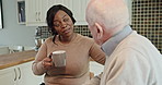 Home, coffee and couple with age gap in conversation, kitchen and interracial love in retirement. Elderly man, young woman and talk with espresso drink in morning, relax together or care in apartment