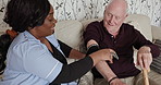 Nurse, senior patient and blood pressure machine on sofa for medical exam, diagnosis or results at old age home. Female person or caregiver monitoring elderly man heart rate in checkup for healthcare