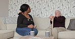 Discussion, healthcare and nurse with senior man with walking stick in living room of house. Communication, medical and African caregiver talk and consulting elderly male patient in retirement home.