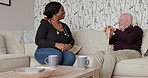Discussion, medical and nurse with senior man with a walking stick in living room of house. Communication, healthcare and African caregiver talking to elderly male patient in retirement home.