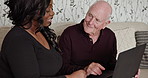 Senior, man and learning on laptop with caregiver in home with conversation about internet or social media. Happy, elderly person and black woman on sofa help with technology, login or streaming web