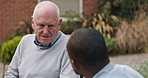 Outdoor, wheelchair and nurse with old man, speaking and support with rehabilitation, helping and healing. Pensioner in a garden, person with disability or caregiver with patient, wellness or empathy