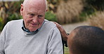 Support, talking and old man with caregiver at park, garden or outdoor, wellness or smile. Senior person with a disability, hand of nurse in conversation or rehabilitation, healthcare or medical help