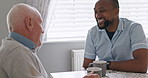 Senior man, caregiver and coffee in kitchen, talking and happy together, relax and enjoy. Retirement, old age and elderly in house, laughing and funny for discussion, female person and living room
