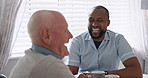 Senior man, caregiver and coffee in kitchen, laughing and happy together, relax and enjoy. Retirement, old age and elderly in house, laughing and funny for discussion, female person and living room
