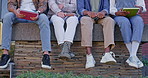 Legs, group or students sitting on campus in college or university for research books or tutoring. Hangout, friends or shoes of people on ledge for class project, learning or school exam preparation