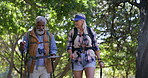 Senior, couple or hiking with stick in nature for retirement wellness, adventure or explore trail. Interracial people, map or walking with help in woods for fitness, trekking or talking with backpack