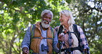 Walking, hiking and senior couple with nature, travel and adventure with woods, conversation and smile. Outdoor, old man or mature woman with happiness, interracial and bonding together with trekking