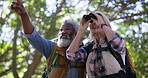 Senior couple, bird watching and hiking with adventure, travel and forest with binoculars. Outdoor, healthy old man or mature woman with fitness, interracial or woods with journey, nature or trekking