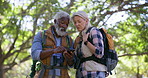 Senior couple, hiking and cellphone for direction, nature and travel with adventure, digital app and outdoor. Activity, old man and mature woman with smartphone, journey and forest with maps and talk