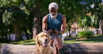 Mature black man, phone and dog in park for relax, funny message and social media on log. Male person, mobile and stroke Golden Retriever in nature for contact, animal blog and care for pet wellness