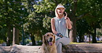 Mature woman, phone call and dog in park for relax, contact and communication on log. Female person, Golden Retriever and mobile in nature for talking, planning and animal care update for wellness