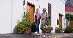 Mature couple, holding hands and smile for on holiday for bonding, break and travel as tourist. Multiracial relationship, people and outdoor on summer vacation to relax, enjoy and fun with walking