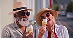 Mature, interracial couple and vacation with ice cream in city for outdoor holiday or summer travel. Elderly man, woman or tourists with smile or hat for sweet dessert on sidewalk in an urban town
