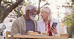 Senior couple, outdoor and conversation with phone at restaurant for internet, research and info. Happy, man and woman with tech at table for network, connection and online review of food on website