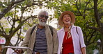 Senior couple, walking and talking in nature for connection, joy or memory as partner. Elderly people, love and outdoor for bonding, interracial relationship and together for health, happiness or fun