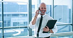 File, phone call and thinking with business man at window of corporate office for communication. Conversation, documents and smile with happy professional employee in workplace for networking