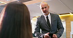 Business man, phone and receptionist at hotel front desk for conversation, appointment and check in info. Executive, talking and concierge for guest registration, booking and reservation with mobile