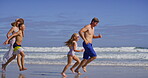 Water, parents and children with running on beach, family vacation and bonding by seaside. Playful, mother and father with kids for holiday journey, connection and happy with holding hands on ocean
