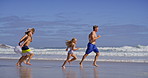 Waves, parents and children with running on beach, family vacation and bonding by seaside. Blue sky, mother and father with kids for holiday journey, connection and happy with holding hands on ocean